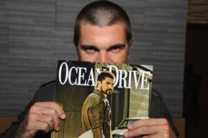 Juanes holding up an Ocean Drive magazine with himself on the cover
