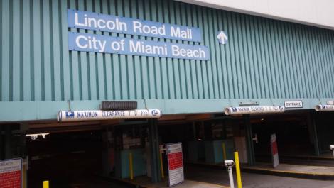 The entrance to a parking garage with a sign reading "Lincoln Road Mall, City of Miami Beach"