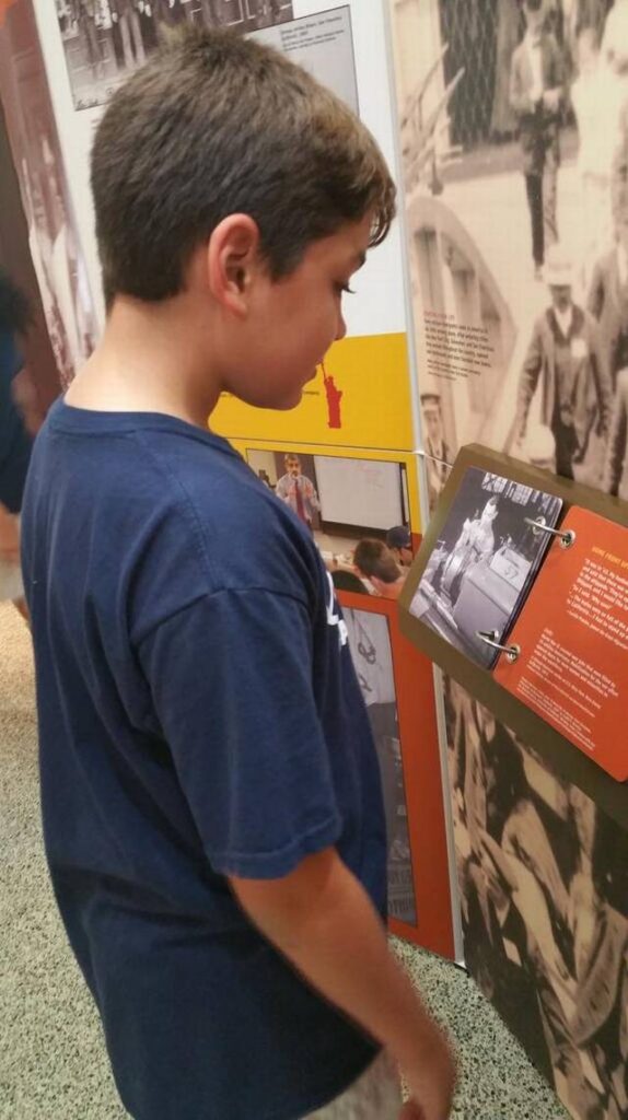 A boy reading an exhibit panel at a traveling Smithsonian exhibition