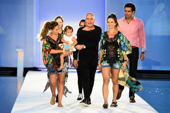 Designer Hernán Zajar walking the runway with models and children at the Colombian swimwear show