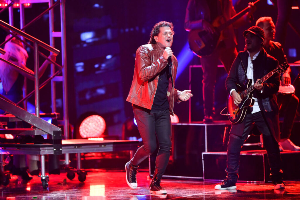Carlos Vives singing on stage beside a guitarist, at Univision's Premio Lo Nuestro