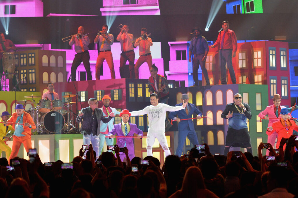 Carlos Rivera and Gente de Zona performing at Premios Juventud on a colourful set of painted buildings