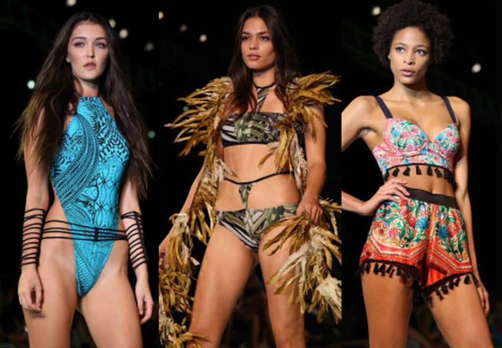 Three models in a printed swimsuit, a feathered top and a printed bralette with fringed shorts