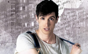 David Cava in a white T-shirt and braces against a background of handwritten lyrics