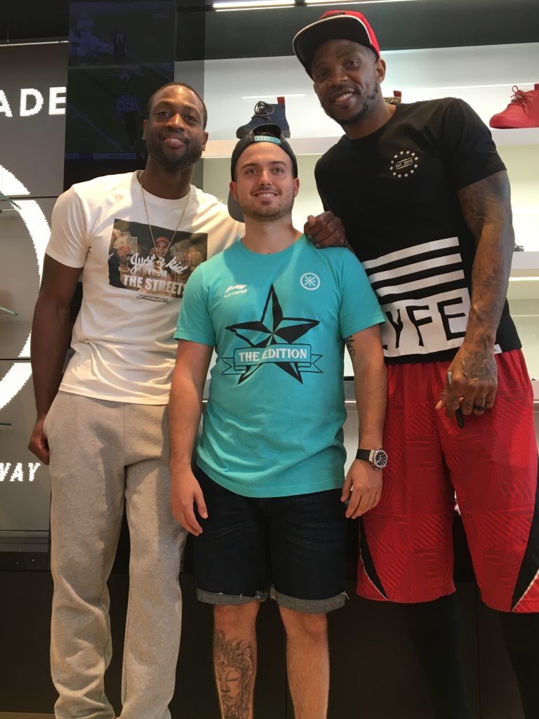 Three men posing together in a sneaker boutique