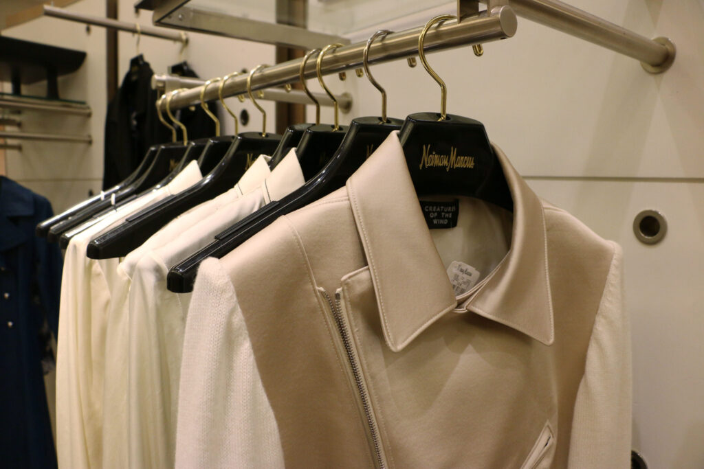 Cream jackets hanging on a rail in a Neiman Marcus store