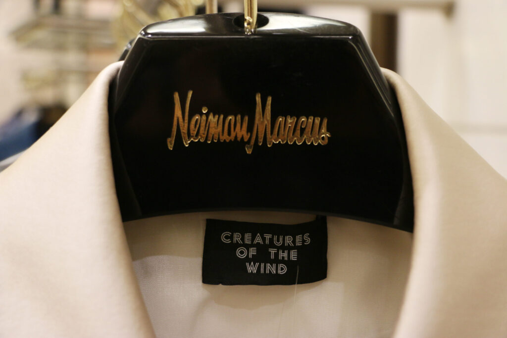 A Neiman Marcus hanger holding a cream garment with a Creatures of the Wind label