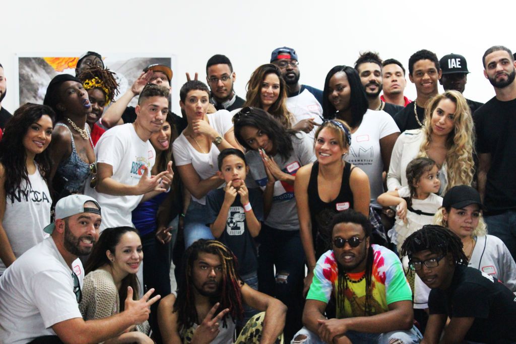 A big group of volunteers posing together in a white gallery