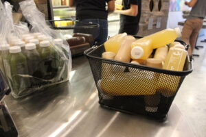 A basket of bottled juices on a counter