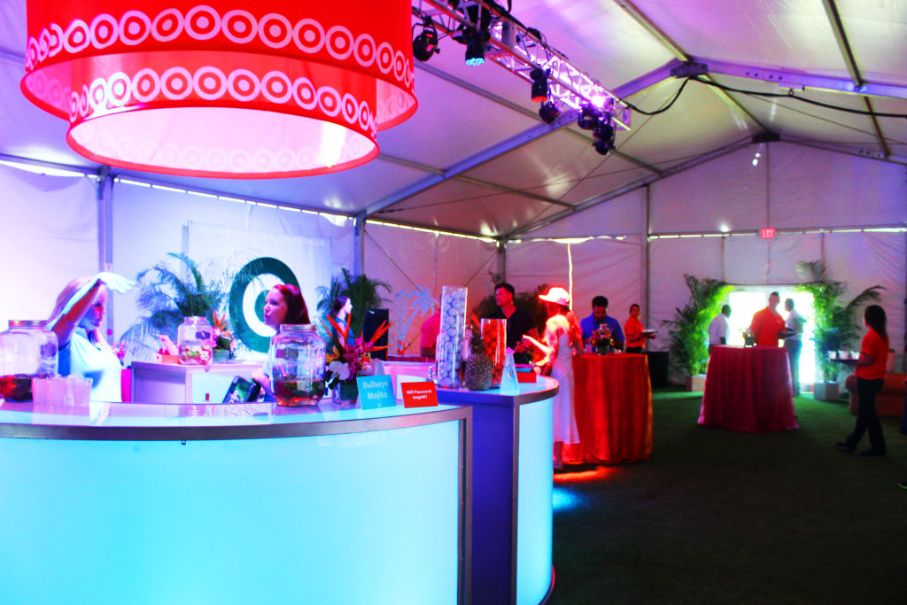 A Target-branded bar and lounge inside a party tent, lit in red and purple