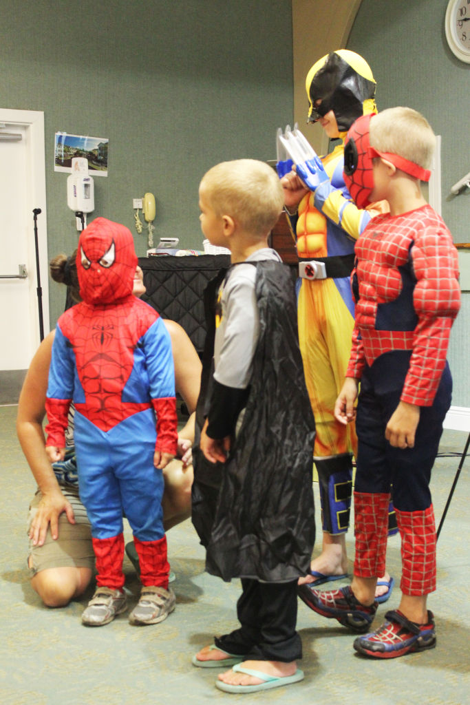 Small children in Spider-Man and superhero costumes playing together