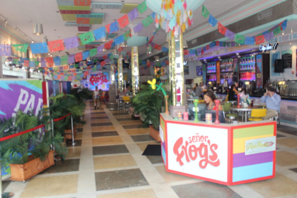 The inside of Señor Frog's with colourful paper bunting and a Señor Frog's kiosk