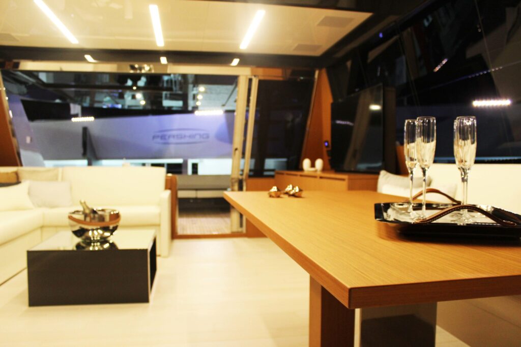 A yacht's white lounge with a wooden table and champagne glasses