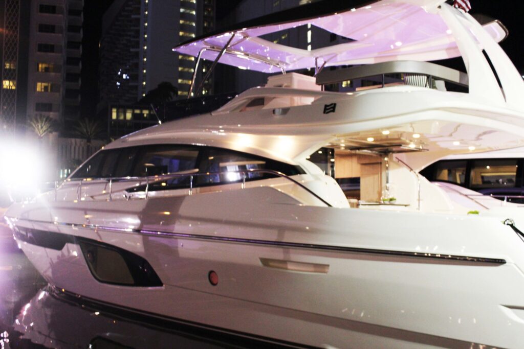 The front of a white luxury yacht lit up at night