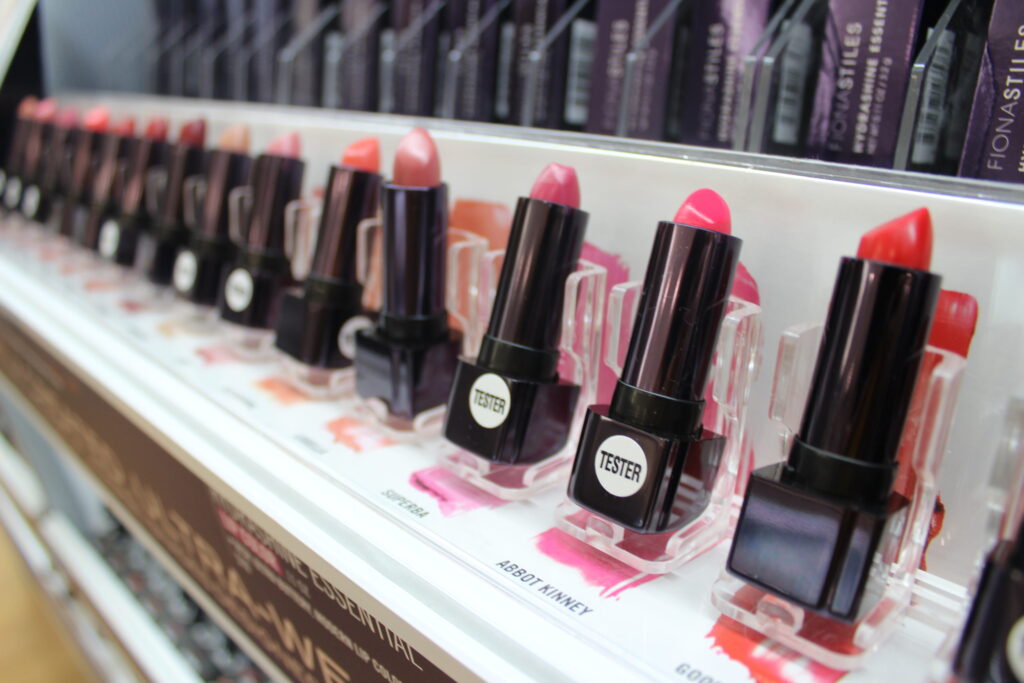 A row of lipstick testers in pinks and reds on a Fionastiles display