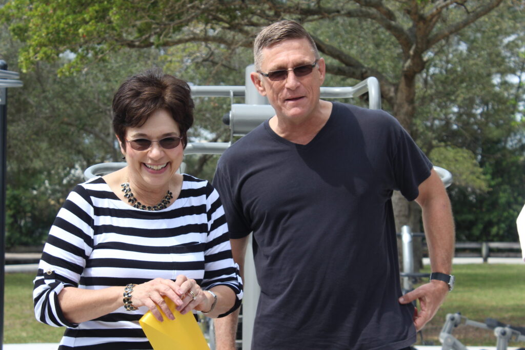 Brenda McClymonds, of the Trust for Public Land, standing beside a man at the new park fitness zone