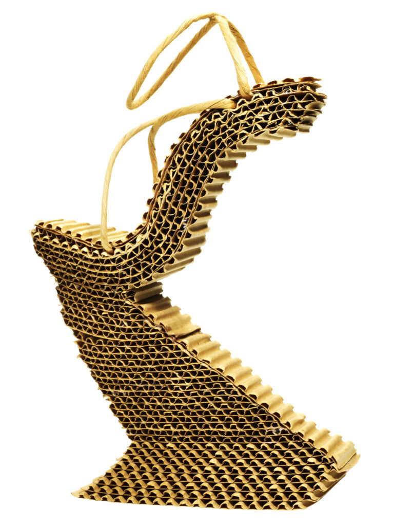 A sculptural gold high heel built from stacked, zigzagging layers