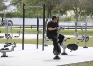 A man using outdoor exercise equipment in a park