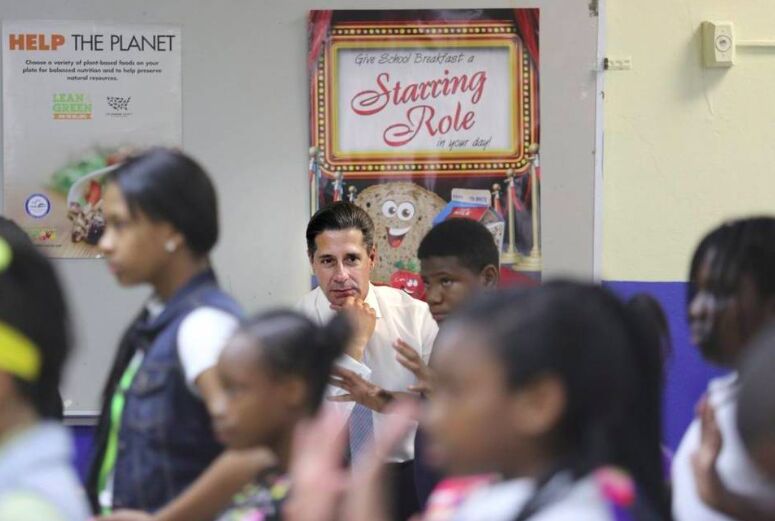 A dance teacher with a group of schoolchildren in a classroom