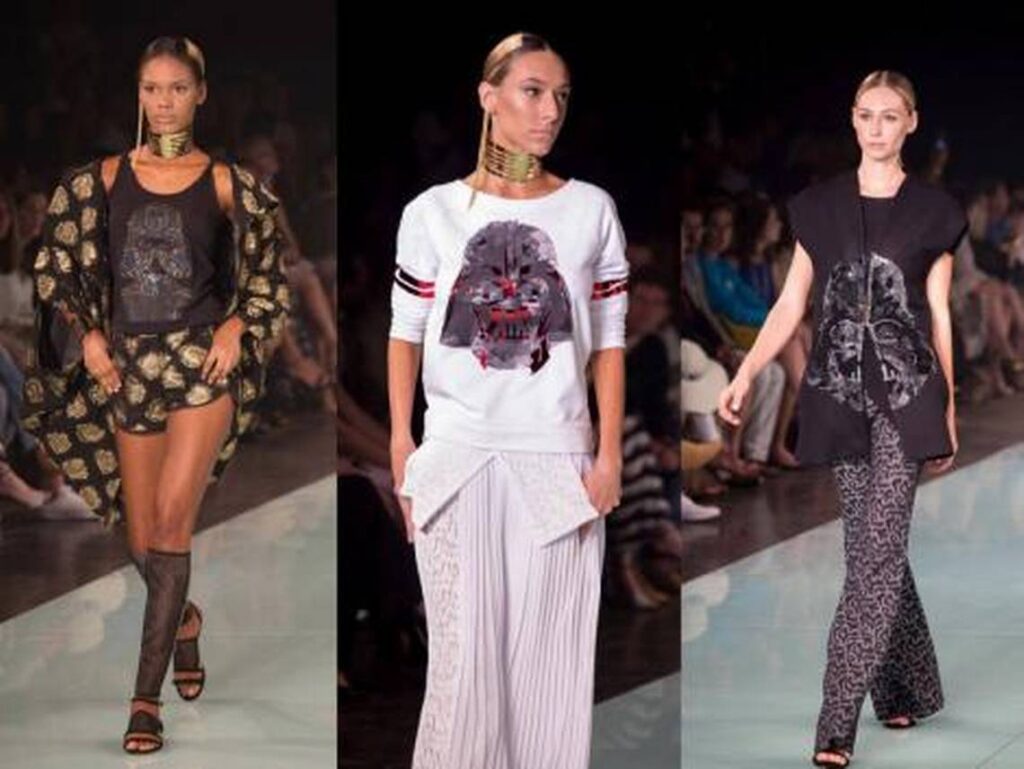 Three models in black-and-white graphic outfits on a runway
