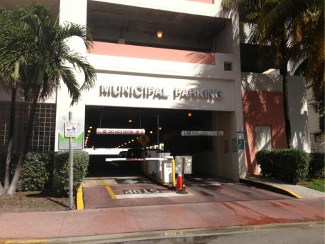 The entrance to a municipal parking garage beside palm trees