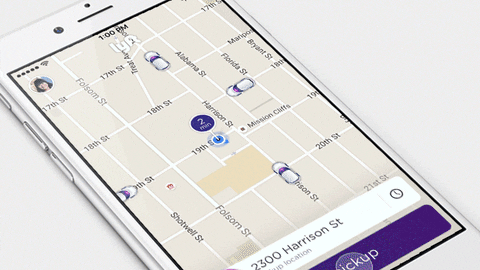 A phone screen showing a ride app map of city streets with cars nearby