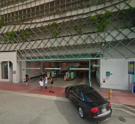 The entrance to a multi-storey car park on a Miami Beach street, a car driving in