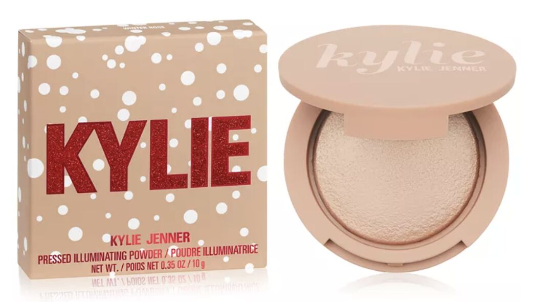 Kylie’s pressed illuminating powder in a glitter-lettered box, beside the open compact of pale shimmer